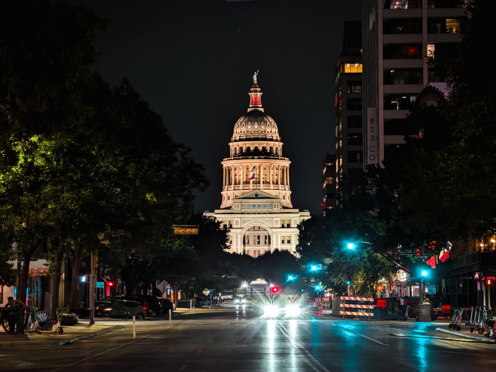 Night view of the illuminated Texas Capitol Building in Austin, captured from downtown street