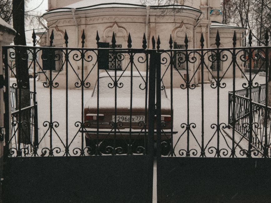 An iron gate in front of an old stone building.